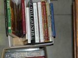 une boîte remplie de livres posée par terre à côté d'une chaise