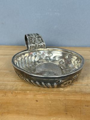 une image représentant un bol en argent posé sur une table en bois