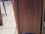 a wooden cabinet sitting on a tile floor in a room