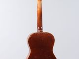 an acoustic guitar hanging from a string on a white background