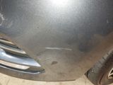 a close up of a car ' s front bumper with a denting on it