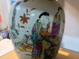 un vase avec un tableau posé sur une table