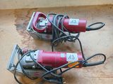 two electric tools sitting on the floor next to each other