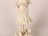 statue of a woman in a dress with a dog on her lap