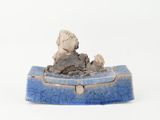 a small blue box with a statue on top of it
