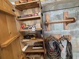 une étagère en bois sur laquelle sont posés des outils, dans un coin de la pièce