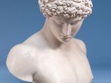 marble bust of a young man with curly hair on a blue background