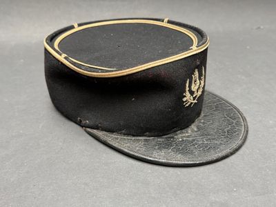 un chapeau noir orné d'un ruban doré sur le dessus