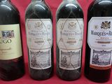three bottles of red wine are lined up on a red background