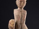 statue d'une femme assise sur une surface noire, avec un fond noir
