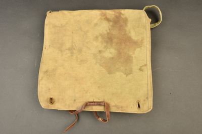 an old leather bag with a brown handle on a gray surface