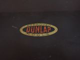 a black suitcase with a brown and orange logo on it
