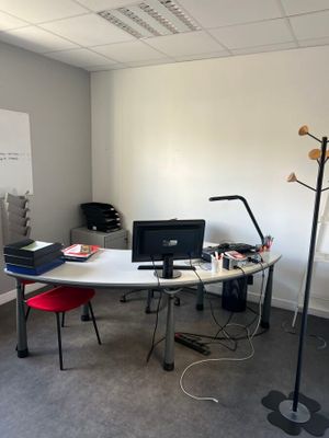 un bureau avec un ordinateur portable et une lampe dans une pièce