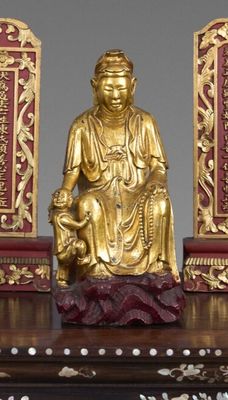 une statue en or représentant une personne assise sur une table