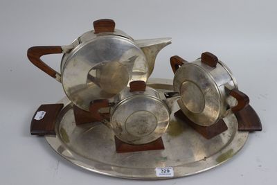 a silver tea set on a silver tray on a white surface