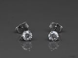 a pair of diamond earrings sitting on top of a table