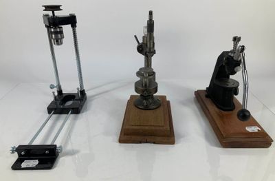 trois types différents de microscopes exposés sur une surface blanche