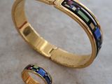 un gros plan sur un bracelet en or et une bague posés sur une table
