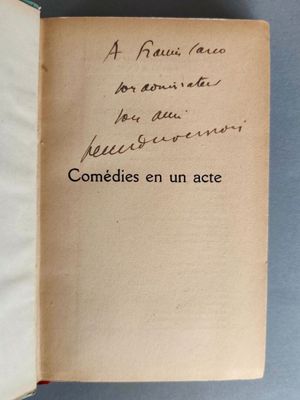un livre ouvert, sur lequel est inscrit un poème manuscrit, posé sur une table