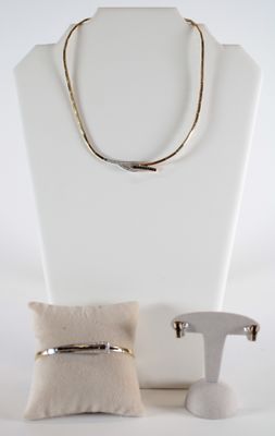 un collier, un bracelet et une bague exposés sur un mannequin blanc