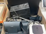une boîte remplie d'appareils électroniques et un ordinateur portable par terre