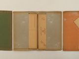several books are lined up in a row on a white surface