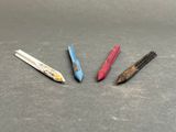 four different colored pencils are lined up on a table