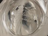 a clear glass bowl with a silver handle on a black surface