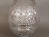 a glass egg shaped object on a stand on a table