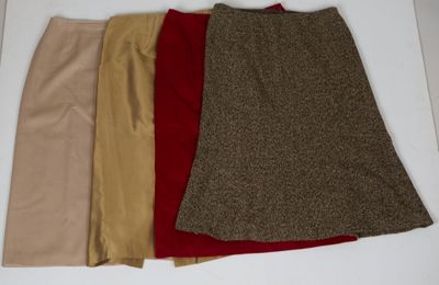 quatre jupes de couleurs différentes disposées sur une surface blanche