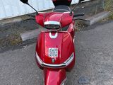un scooter rouge garé devant un immeuble