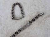 un bracelet en argent et un autre bracelet en argent posés sur une surface blanche
