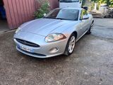 a picture of a silver sports car parked in front of a garage