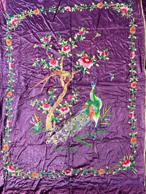 an image of a purple quilt with a peacock and flowers on it