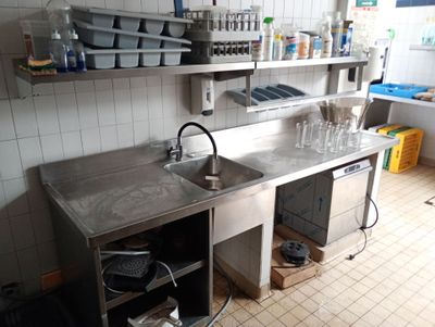 une cuisine avec un évier et un comptoir sur lequel se trouve de la vaisselle