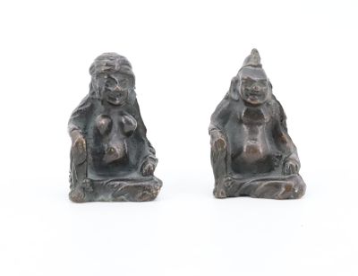 deux figurines d'un homme et d'une femme assis sur un banc