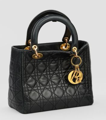 un petit sac noir avec des finitions dorées sur la poignée