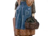 figurine of a woman sitting on a chair holding a suitcase