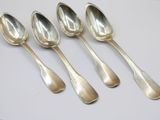 six silver spoons sitting on top of a white surface