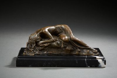 bronze sculpture of a woman laying on a marble base