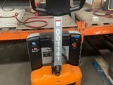 an orange and black forklift sitting on top of a pallet in a warehouse