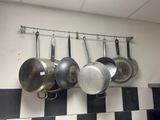 pots and pans hanging on the wall in the kitchen