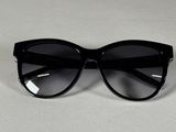 des lunettes de soleil noires de style « œil de chat » posées sur une surface blanche