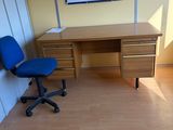 un bureau avec une chaise bleue et un tableau accroché au mur