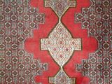 a red rug with a diamond design on it