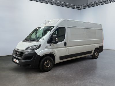 La camionnette blanche est garée à l'intérieur d'une grande pièce blanche.