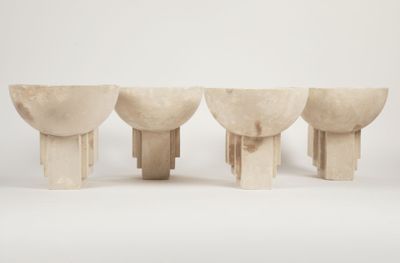 three white marble vases sitting on top of each other