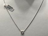 Collier en métal argenté avec un pendentif en diamant, présenté sur un mannequin blanc