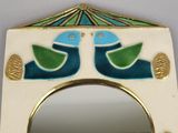 a mirror with a bird design on it and a mirror with a bird design on it