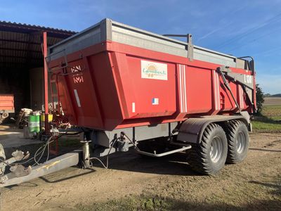 un camion-benne rouge garé devant un immeuble